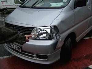 Front of van showing damaged light and dent to body work