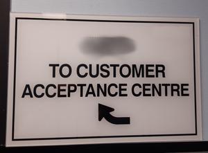 Sign directing 'To Customer Acceptance Centre'