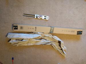 Small pacet of two cable ties next to very long cardboard box